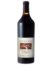  Rockford Basket Press Shiraz<br>2009  750mL Rockford Basket Press Shiraz has garnered a unique and cult following over its lifetime. With its 'old school' brown glass bottle and traditional label, Rockford Basket Press is one for the traditionalists. Big, bold and upfront fruit with all the lashings of chocolate, coffee bean and Christmas cake all have come to adore. The 2009 Rockford is a remarkable wine considering the difficulties of the warm vintage. Primary fruit characters of cherry and blackberry are prevalent now with a dense mout